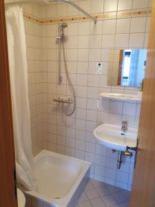 La salle de bains est pourvue d'une baignoire, d'un lavabo et d'une douche. dans l'établissement Stay2Night Hotel, à Dillingen