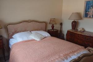 een slaapkamer met een bed met een roze deken en 2 lampen bij Spacious 70 m flat with Balcony and sea view! in Cannes