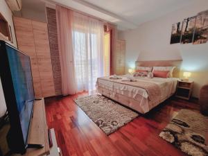 a bedroom with a bed and a flat screen tv at Apartman Temida Lux in Vrnjačka Banja +13 photos