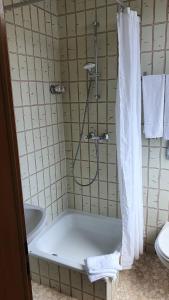 a bathroom with a shower with a tub and a sink at Stay2Night Hotel in Dillingen an der Saar