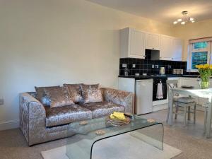 a living room with a couch and a kitchen at Self contained, spacious annex with private drive. in Kent