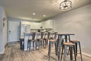 a kitchen with bar stools and a kitchen with white cabinets at Camdenton Condo with Pool Access and Lake Views! in Camdenton