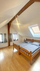ein Schlafzimmer mit einem Holzbett im Dachgeschoss in der Unterkunft Penzion Panská in Budweis
