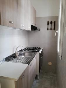 una cucina con lavandino e piano cottura forno superiore di Villa Marisole a Torre Canne