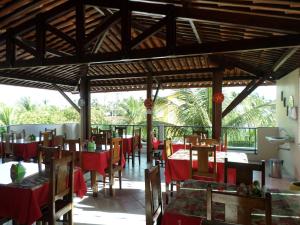a restaurant with red tables and chairs in a room at Pousada Recifes de Corais in Porto De Galinhas