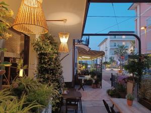 un patio con tavoli, sedie e luci di B&B La Volpina a Rimini