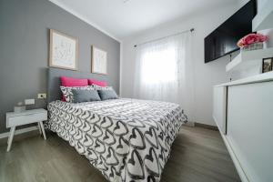 1 dormitorio con 1 cama y TV en Vivienda Vacacional Efriland, en La Frontera