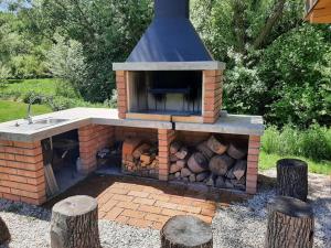 un four en brique avec un tas de bois de chauffage dans l'établissement Dom na jazere, à Pliešovce