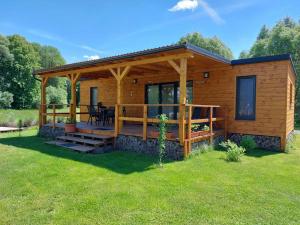 une cabane en rondins avec une terrasse et une table dans l'établissement Dom na jazere, à Pliešovce