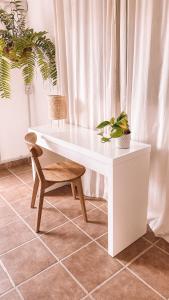 a white desk with a chair and a plant at Siempre Feliz La Casita Los Molinos in Villaverde