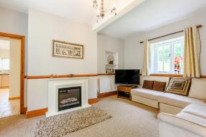 a living room with a couch and a fireplace at Distyll in Ruthin