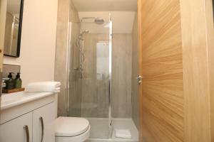 a bathroom with a shower with a toilet and a sink at Garden Studio in Biggar in Biggar +23 photos