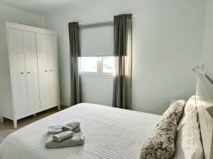 プラヤ・オンダにあるApartamento Las Playasのベッドルーム1室(ベッド1台、タオル2枚付)