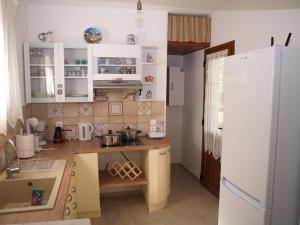 a kitchen with white cabinets and a white refrigerator at ilioni house in Skopelos Town