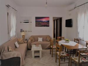 a living room with a couch and a table at ilioni house in Skopelos Town