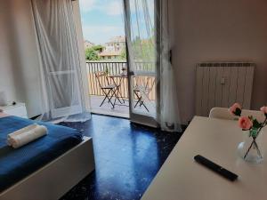 a room with a bed and a table and a balcony at PORTA A MARE STATION in Pisa