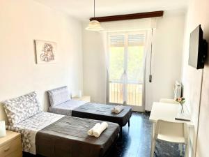 a bedroom with a bed and a couch and a window at PORTA A MARE STATION in Pisa