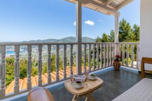 a balcony with a table and a view of the ocean at Liagka Villa in Skopelos Town