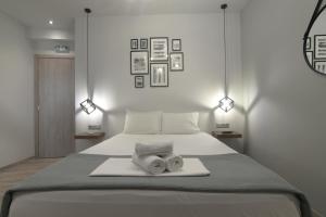 a bedroom with a bed with towels and pictures on the wall at Feel Athens Studios at Monastiraki in Athens