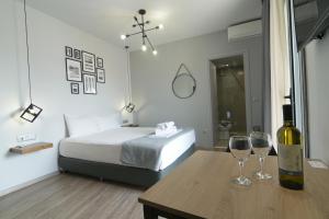 a bedroom with a bed and two wine glasses on a table at Feel Athens Studios at Monastiraki in Athens