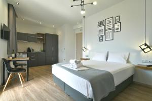 a bedroom with a bed and a desk and a kitchen at Feel Athens Studios at Monastiraki in Athens