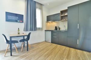 a kitchen with a table and two chairs and a table and cabinets at Feel Athens Studios at Monastiraki in Athens