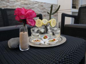 una mesa con una bandeja de bebidas y un jarrón con una flor en Fashion Villa Vivalavida, private pool x parking, en Playa Blanca