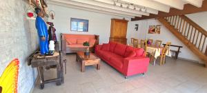 a living room with a red couch and a table at La Gelotière maison de compagne à 10 min du Puy du Fou in Sevremont