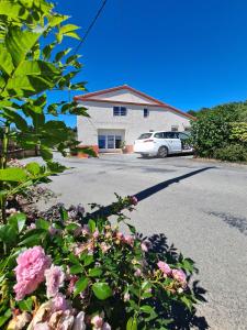 une voiture blanche garée devant une maison dans l'établissement La Gelotière propose 2 logements indépendants à 10 min du Puy du Fou, à Sevremont