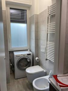 uma casa de banho com um WC e uma máquina de lavar roupa em Milano Fiera City - Apartments em Milão