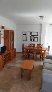 HABITACIONES EN frente DEL PUERTO في ألميريا: غرفة معيشة مع طاولة وكراسي وأريكة