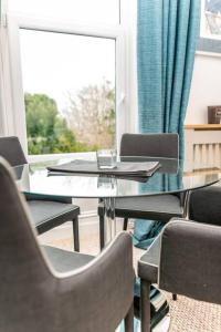 a table and chairs in a room with a window at * POPULAR * Stunning quiet apartment by the sea in Torquay