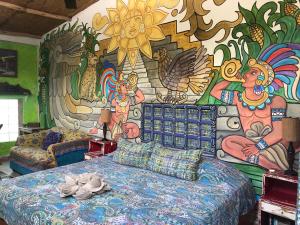 una camera da letto con un letto e un murale sulla parete di Majikal B&B - Pueblo Maya a Mérida