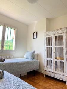 1 dormitorio con 2 camas y ventana grande en Casa Palau - Relax y naturaleza a los pies del Montseny Arbúcies, en Arbúcies