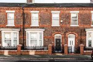 a red brick building with white windows and a door at The Anfield Inn in Liverpool