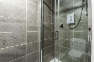 a bathroom with a shower with a glass door at The Anfield Inn in Liverpool