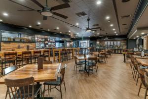 a restaurant with wooden tables and chairs and a bar at Best Western Plus Hilltop Inn in Redding