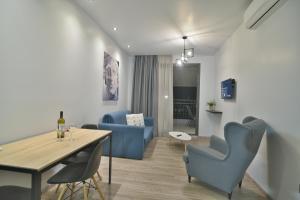 a living room with a blue couch and a table at Feel Athens Studios at Monastiraki in Athens