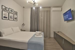 a bedroom with a bed and a tv on the wall at Feel Athens Studios at Monastiraki in Athens