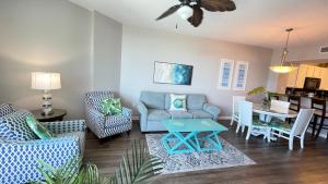 a living room with a couch and chairs and a table at Spectacular Sunsets 5 star Resort Condo Across from Beach Sleep 6 Private Shuttle in Destin