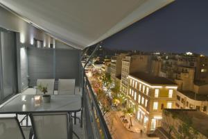 a balcony with a view of a city at night at Feel Athens Studios at Monastiraki in Athens