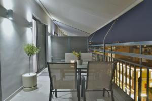 a balcony with a table and chairs on a building at Feel Athens Studios at Monastiraki in Athens