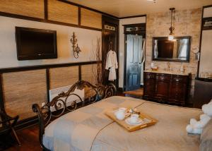 a bedroom with a bed with a television and a sink at Auberge Bruine Océane in Matane