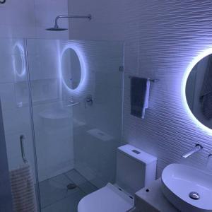 La salle de bains est pourvue de toilettes, d'un lavabo et d'un miroir. dans l'établissement Playa sur, 5 min playa camina, machado, olas!, à Mazatlán