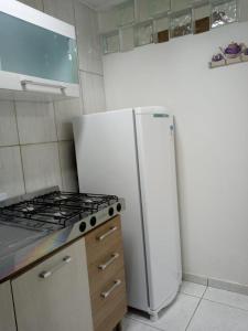 a kitchen with a white refrigerator and a stove at Espaço completo bem localizado c estacionamento in Foz do Iguaçu