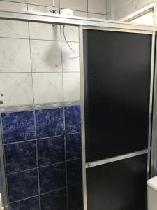 y baño con ducha y puerta de cristal. en Espaço completo bem localizado c estacionamento, en Foz do Iguaçu