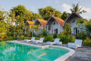 a villa with a swimming pool in front of a house at Kayu Kuning Cottage in Nusa Penida