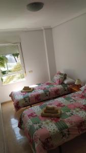 a bedroom with two beds and a window at HABITACIONES EN frente DEL PUERTO in Almería