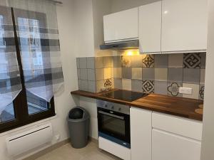 een keuken met witte kasten en een fornuis met oven bij Magnifique appartement de 60m2 in Le Blanc-Mesnil