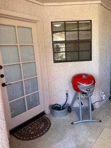 un taburete rojo sentado frente a una puerta en Catalina Condo @ LaEncantada - Tucson AZ en Tucson
